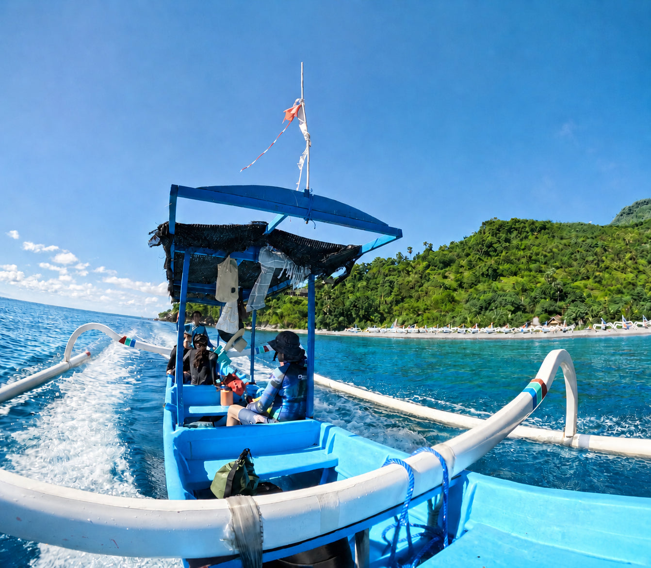Three freedivers sitting on a local jukung boat in Amed Bali preparing for a freedive