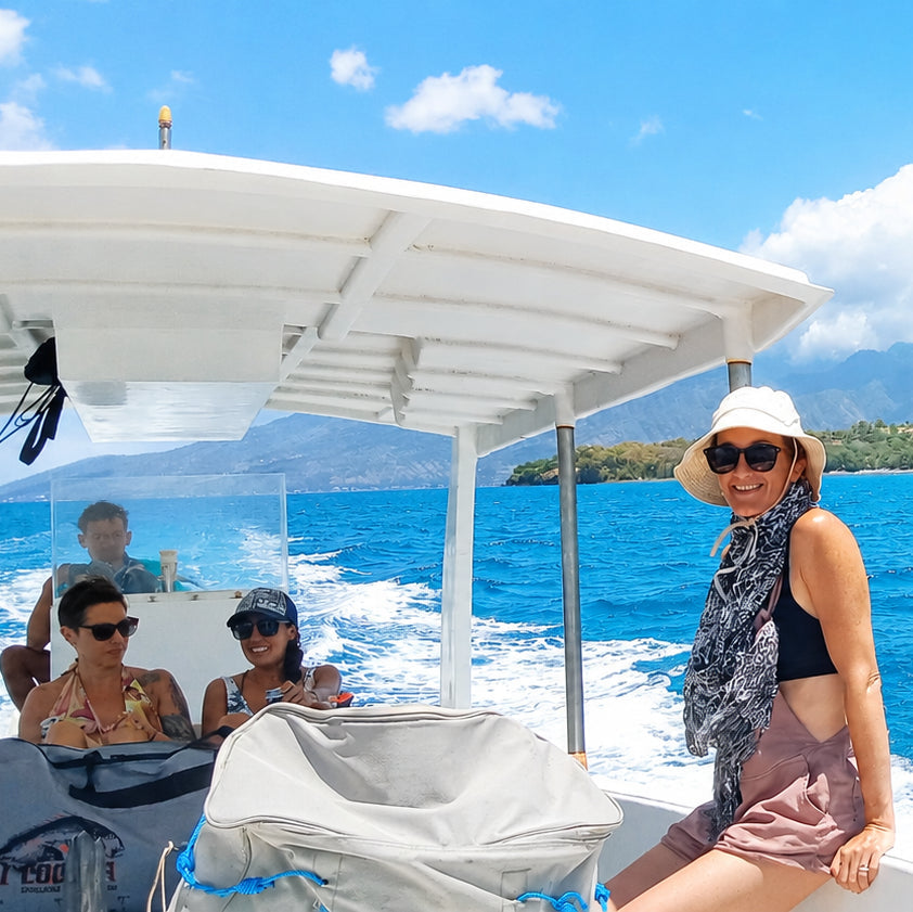 Three women sitting on a speedboat traveling offshore in North Bali to a freediving spot